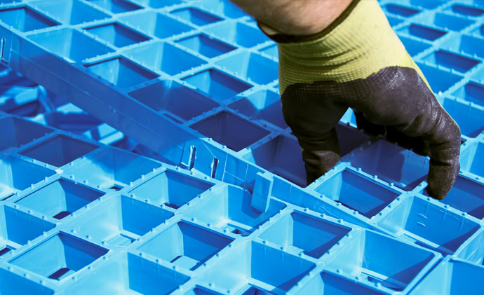 an image showing a worker handle the blue accugrid surface grating from Brentwood Industries