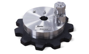 A Polychem torque limiter features a round, metallic body mounted on a black cogwheel-shaped base. The device has a cylindrical attachment on top with bolts and a label containing brand information.