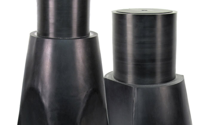 Two dark steel chamfer-style weights with cylindrical tops and wider, tapering bases resemble stub shafts. The weights are uniform in color with a smooth, matte surface finish.