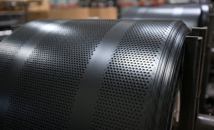 a close up showing two bundles of koroseal perforated plate wrap from Brentwood Industries