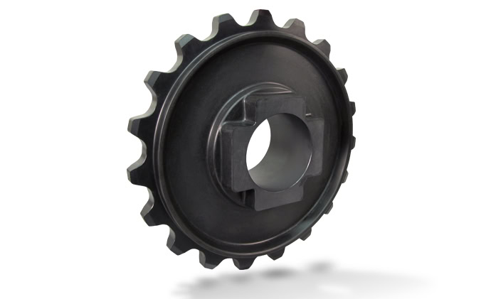 A metal sprocket with evenly spaced teeth along its outer edge, a circular hole in the center, and additional squared and rectangular cutouts surrounding the hole.