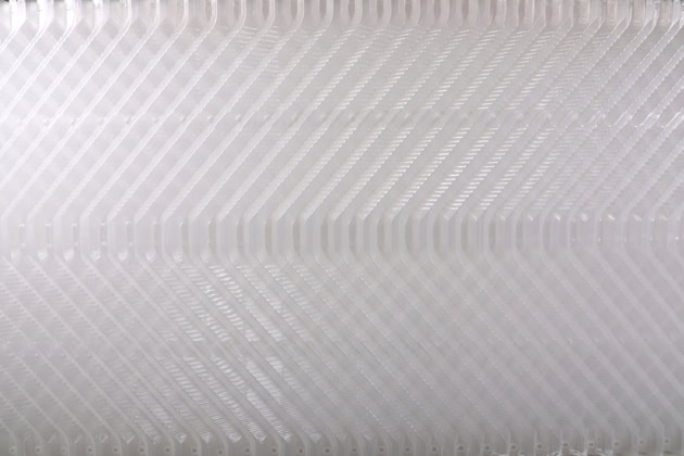 Close-up of repeated, overlapping, translucent white plastic ridges creating a geometric and textured pattern. It is showing a side detail view of the 250 HTE