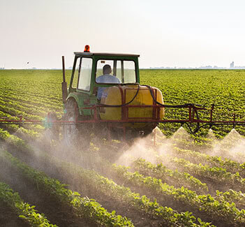 a farm sprayer being used on a field of crops