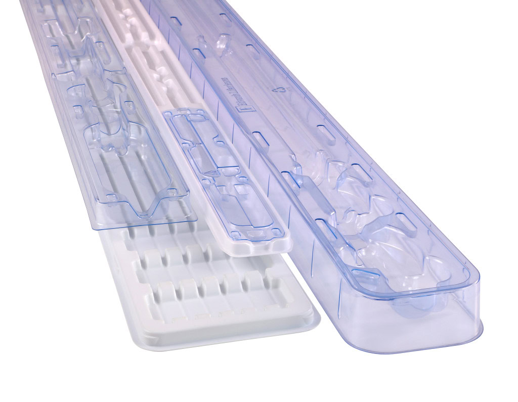 A detailed image shows several transparent and white plastic trays with intricate compartments, designed for organizing and storing medical instruments or devices.