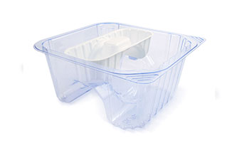 A transparent plastic medical tray with a small separate compartment.