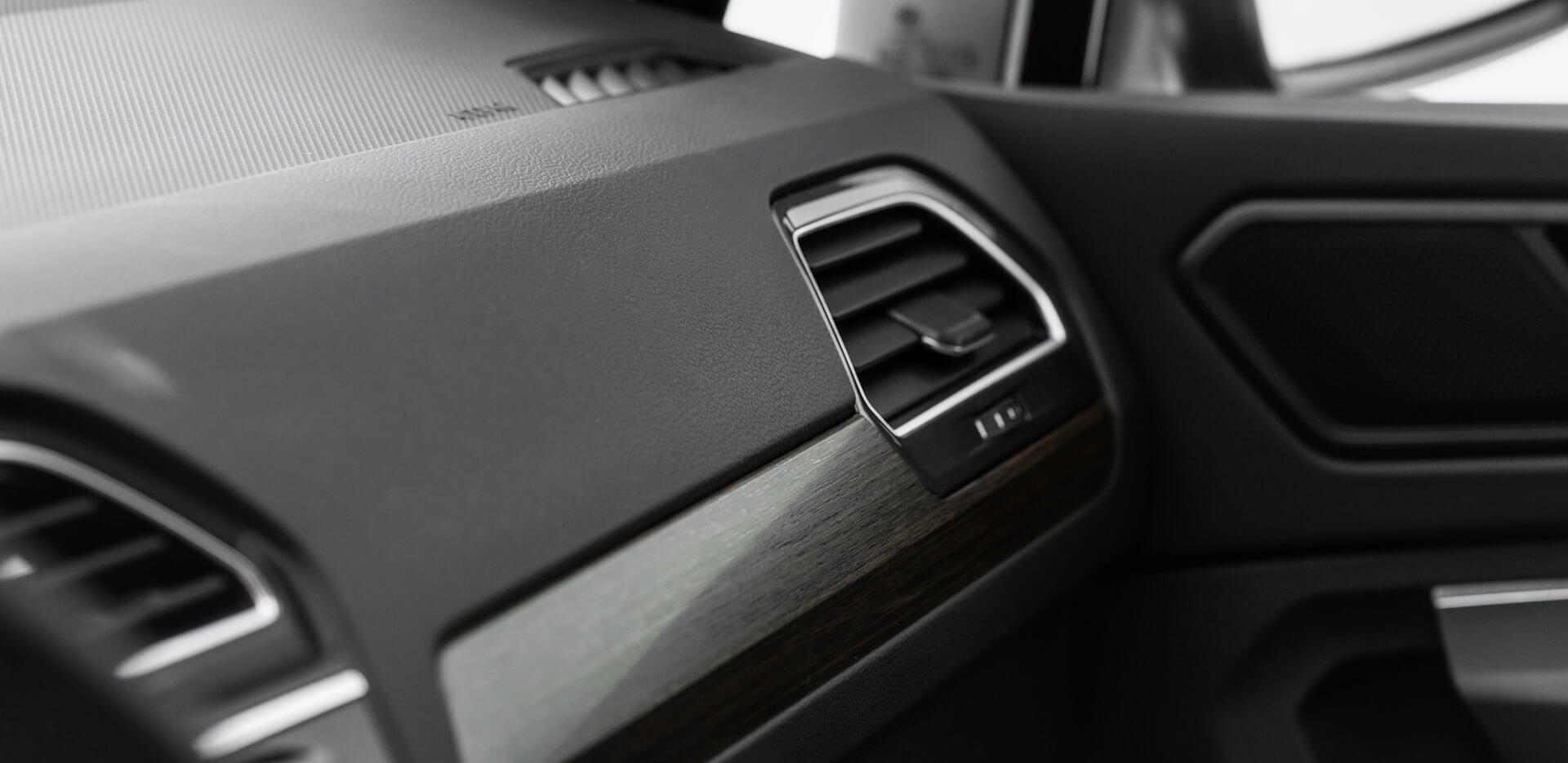 Close-up of a car's interior showing the air conditioning vent on the dashboard. The design features a combination of matte and glossy finishes.