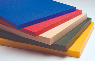 A stack of rectangular HDPE sheets in different colors, including blue, red, beige, green, and yellow, is arranged diagonally.