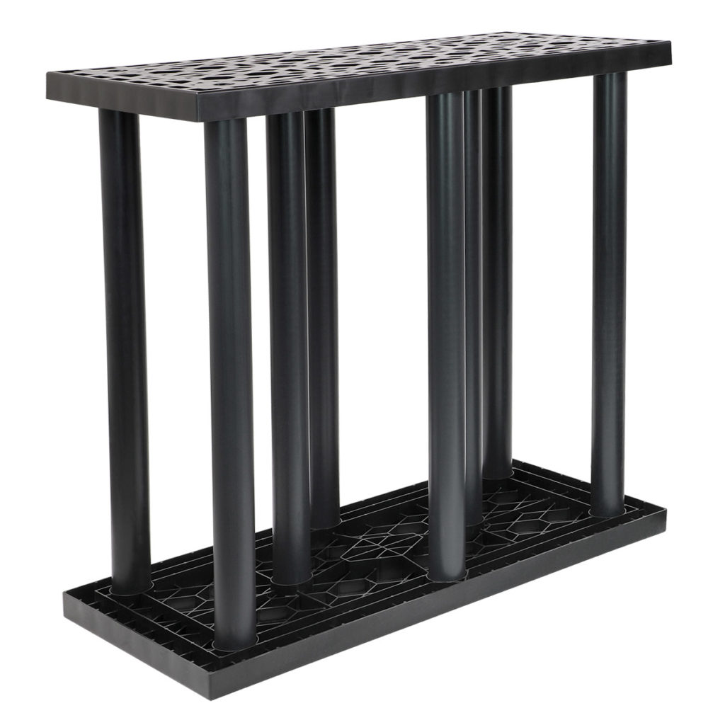 A black, rectangular rack with a grid-like top and solid base, supported by cylindrical vertical tubes.