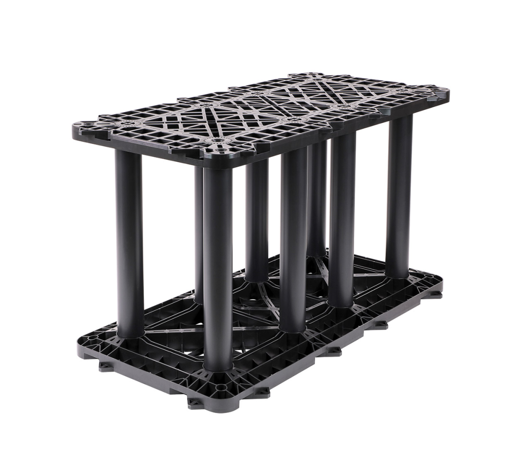 A black plastic stackable pallet with a grid-like surface, supported by multiple vertical cylindrical columns.