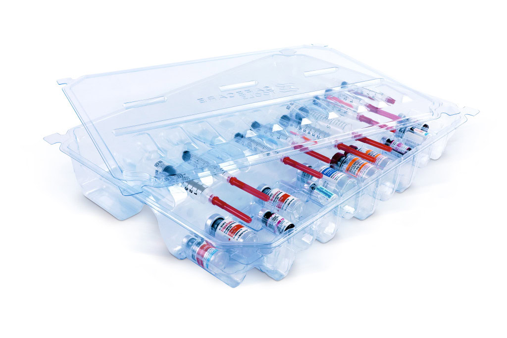 A plastic tray with multiple vials of medication enclosed in clear plastic covers. Several red-capped syringes are visible, secured in the designated spaces within the tray. The tray lid is partially open, revealing the orderly arrangement of medical contents inside.