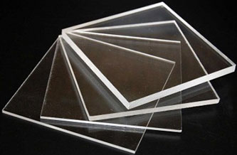 A fan-like arrangement of six clear acrylic sheets is displayed against a dark background. Each sheet, crafted from premium resins, is thin, rectangular, and slightly overlapping the next.