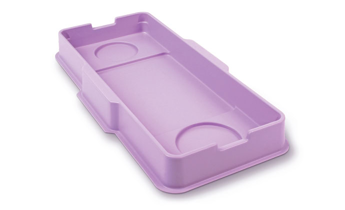 Bandeja rectangular de plástico de color morado claro con dos hendiduras circulares en esquinas diagonalmente opuestas. La bandeja tiene bordes elevados y varios pequeños cortes rectangulares a lo largo de los lados.