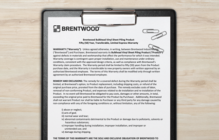 Close-up of a clipboard holding a printed document. The document header reads "Brentwood" and includes warranty terms and conditions.