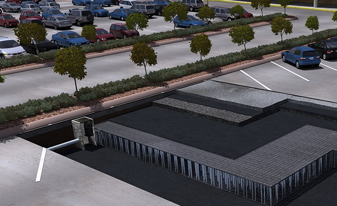 A cross-sectional view of a parking lot showing an underground stormwater management system. The setup includes a large underground basin beneath the parking spaces.