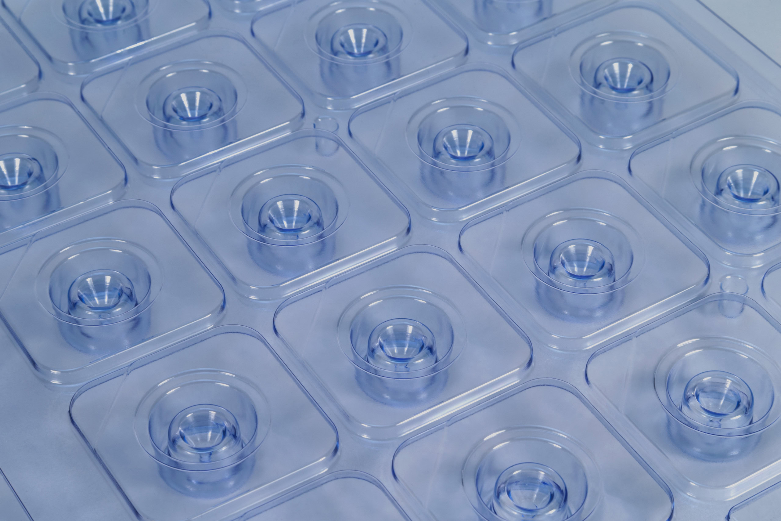 Clear plastic packaging with multiple round cavities, arranged in a grid pattern created using Brentwood's light gauge thermoforming capabilities